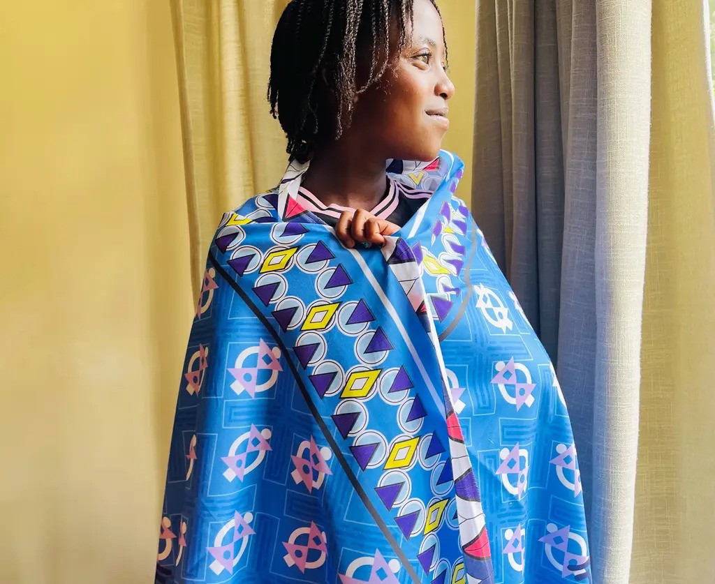 Maya wrapped in a khnaga leso design by UndaMeta. Print: Sharake Cool by Tessie Gachoka (2026)